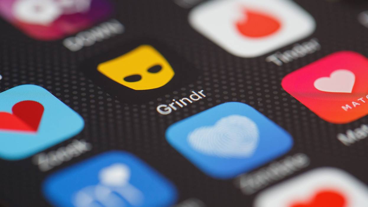 The Grindr app logo is seen among other dating apps on a mobile phone screen.