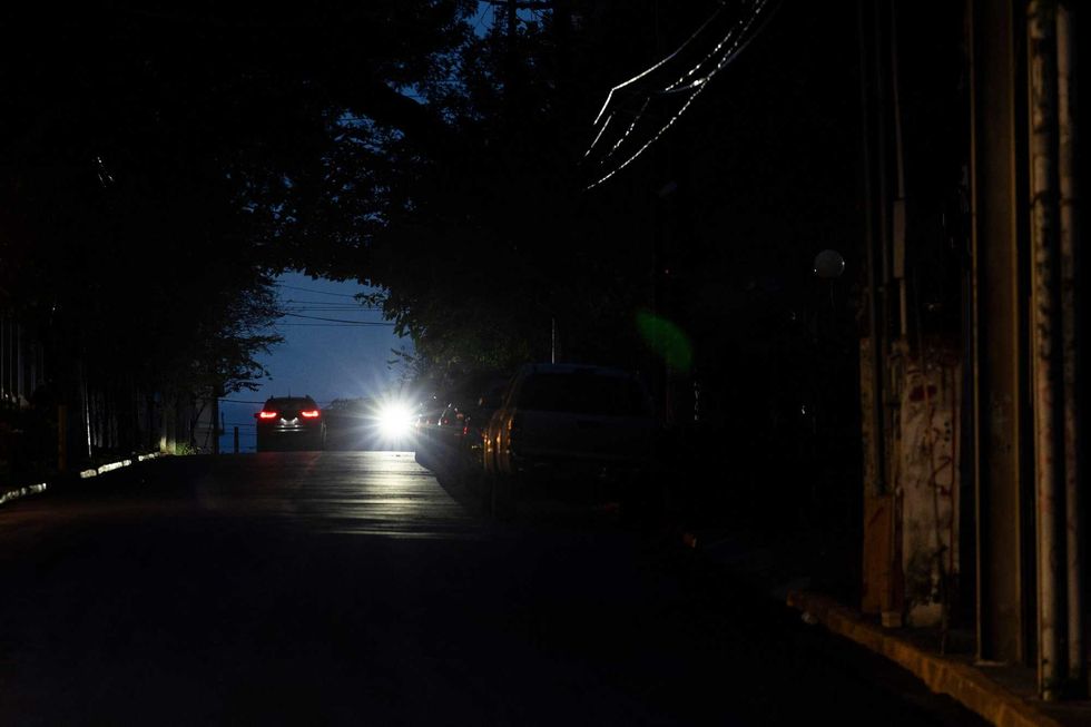 The headlights of a car lights up a dark street in San Juan, Puerto Rico after a major power outage hit the island on December 31, 2024