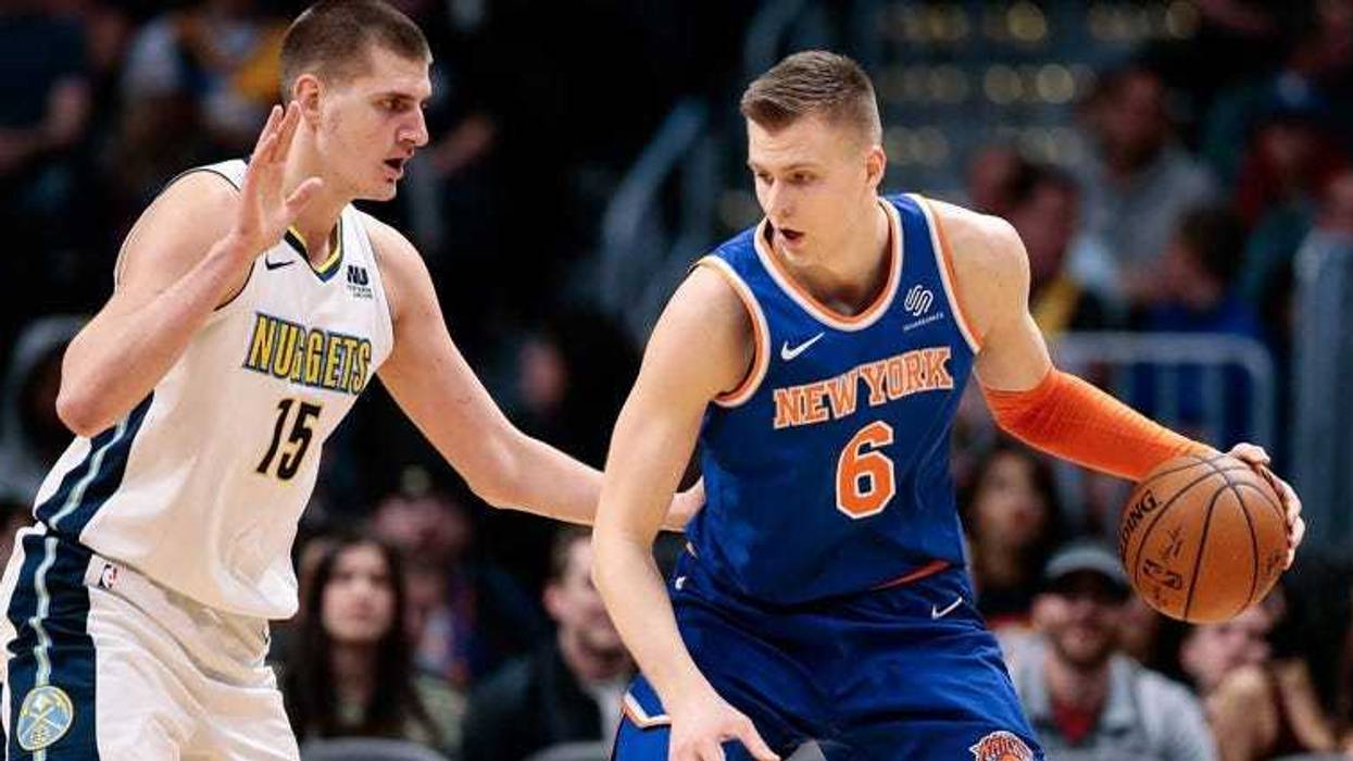 The Knicks' Kristaps Porzingis dribbles against the Nuggets' Nikola Jokic on Jan. 25, 2018 at the the Pepsi Center in Denver.