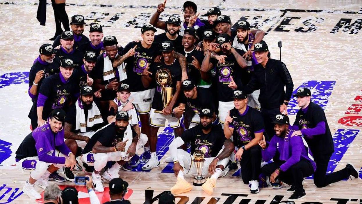 The Los Angeles Lakers pose for a team photo with the trophy after winning the 2020 NBA Championship over the Miami Heat in Game Six of the 2020 NBA Finals at AdventHealth Arena at the ESPN Wide World Of Sports Complex on October 11, 2020 in Lake Buena Vista, Florida.