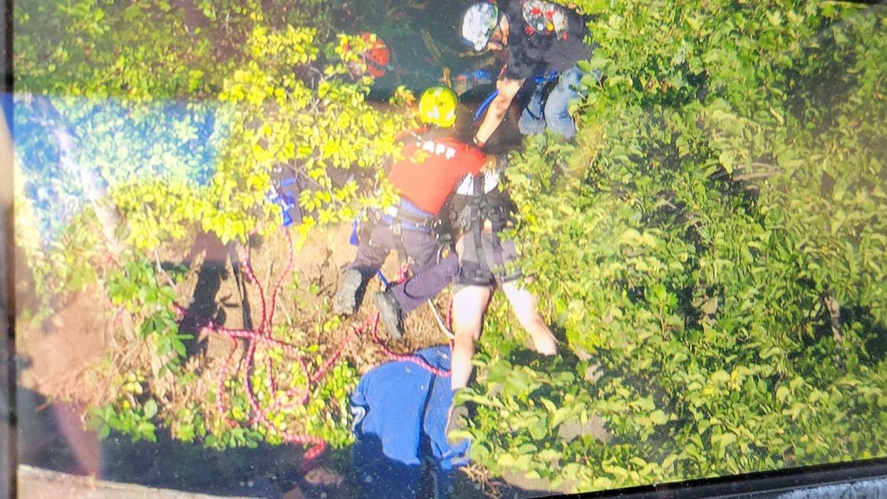 The man landed in a crevice between two rocks instead of falling 250 feet, officials said