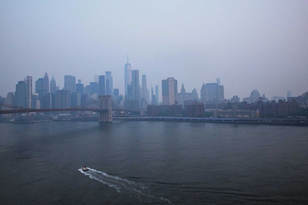The Manhattan skyline is seen during sunrise amid hazy conditions due to smoke from the Canadian wildfires on June 8, 2023 in New York City