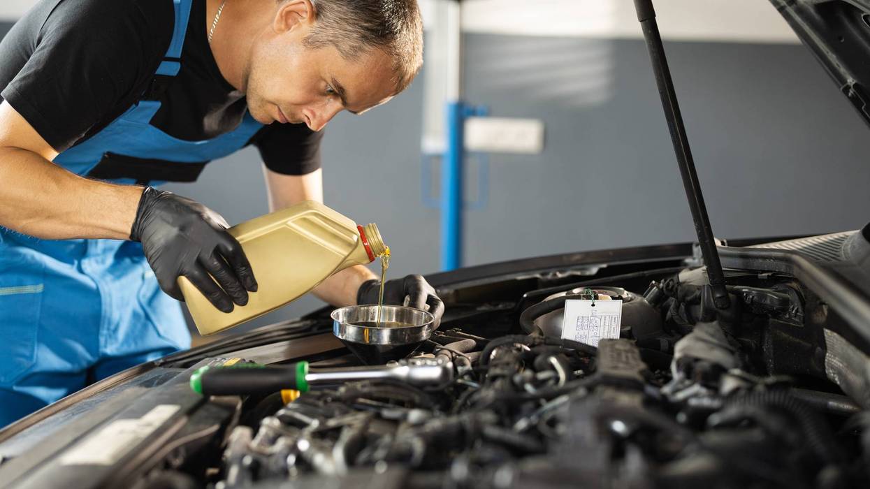 The mechanic completing auto oil change.