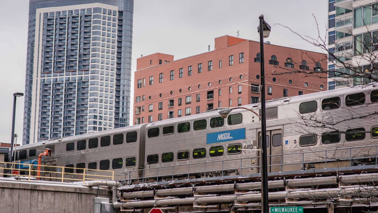 The Metra train passes above on elevated tracks, downtown Chicago. Millions take public transit yearly in the city.