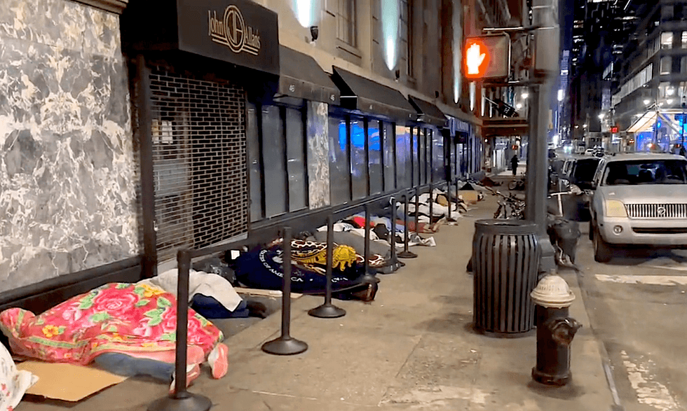 The migrant men have been sleeping for days on the sidewalk