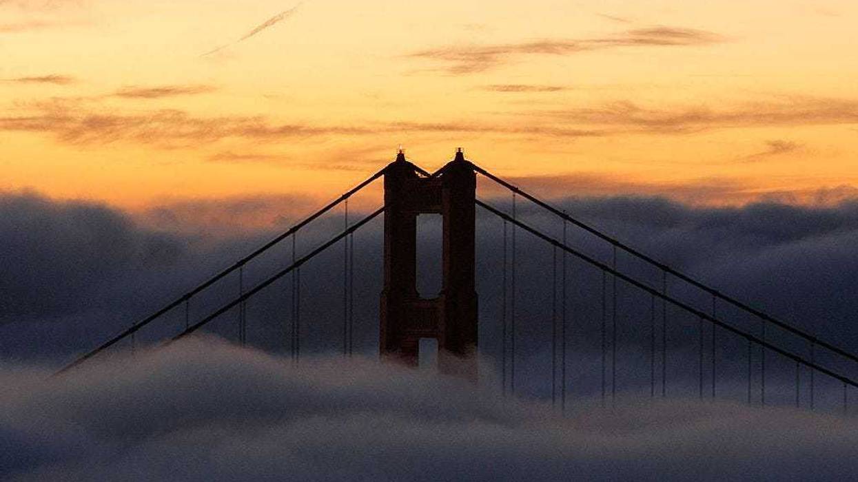 The north tower of the Golden Gate Bridge is blanketed by fog as the sun rises October 8, 2007 in Sausalito, California.