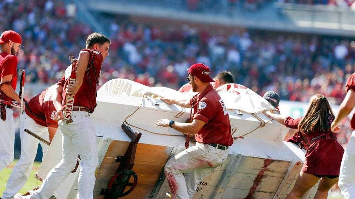 The Oklahoma Sooner Schooner flipped over during a touchdown celebration on the field during the first half of an NCAA college football game against West Virginia in Norman, Okla., Saturday, Oct. 19, 2019.