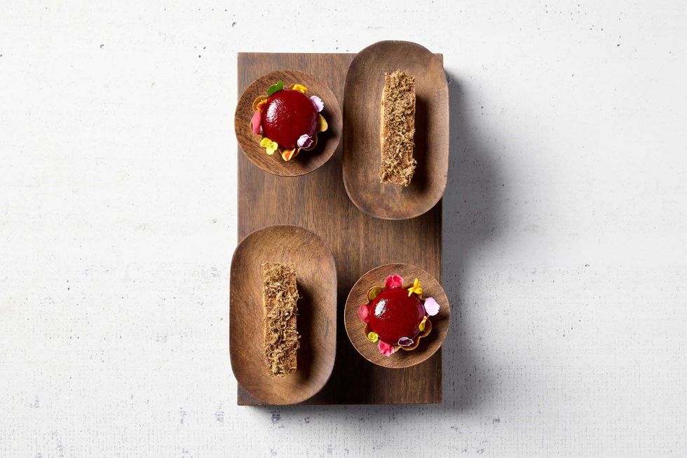 The pani puri (top left and bottom right) and the galouti (top right and bottom left) at Indienne. Although the two dishes change slightly with each new menu, the latest version of the pani puri features blackberry and tamarind in a buckwheat tart, while the galouti is an eclair with mushroom, goat cheese, and truffle