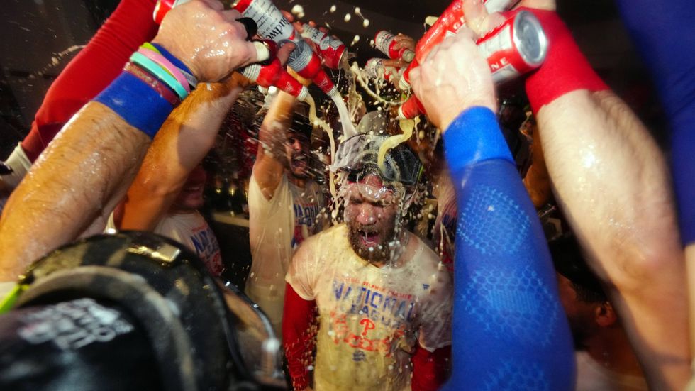 The Philadelphia Phillies celebrate in the locker room after defeating the San Diego Padres in Game 5 to win the National League Championship Series at Citizens Bank Park on Oct. 23, 2022.