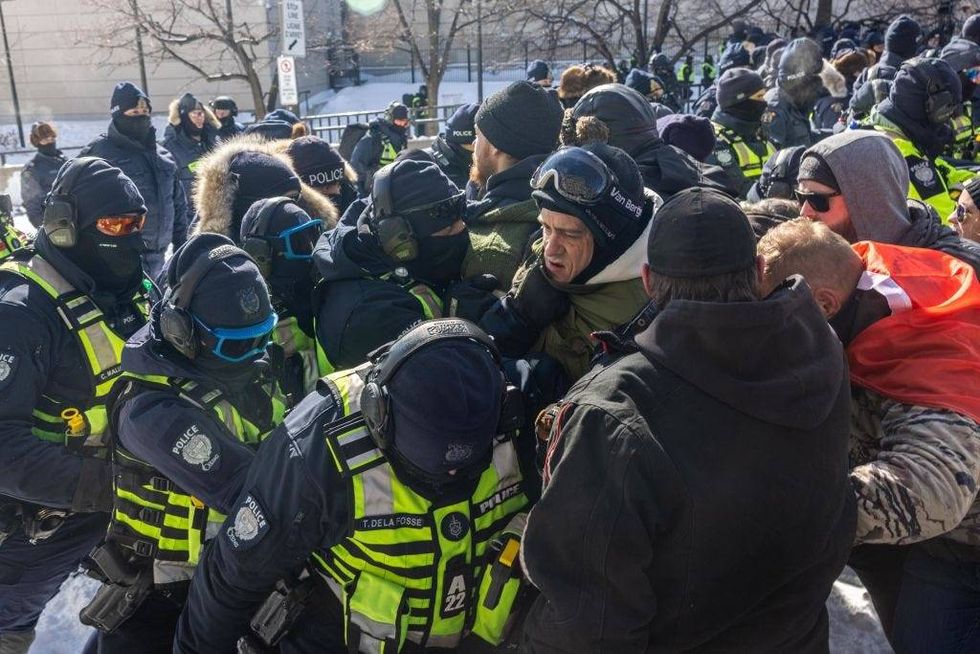The police push protestors back on February 18, 2022 in Ottawa, Ontario, Canada. Demonstrators gathered to occupy the area surrounding Parliament Hill as a protest vaccine mandates and restrictions brought on by the spread of COVID-19.