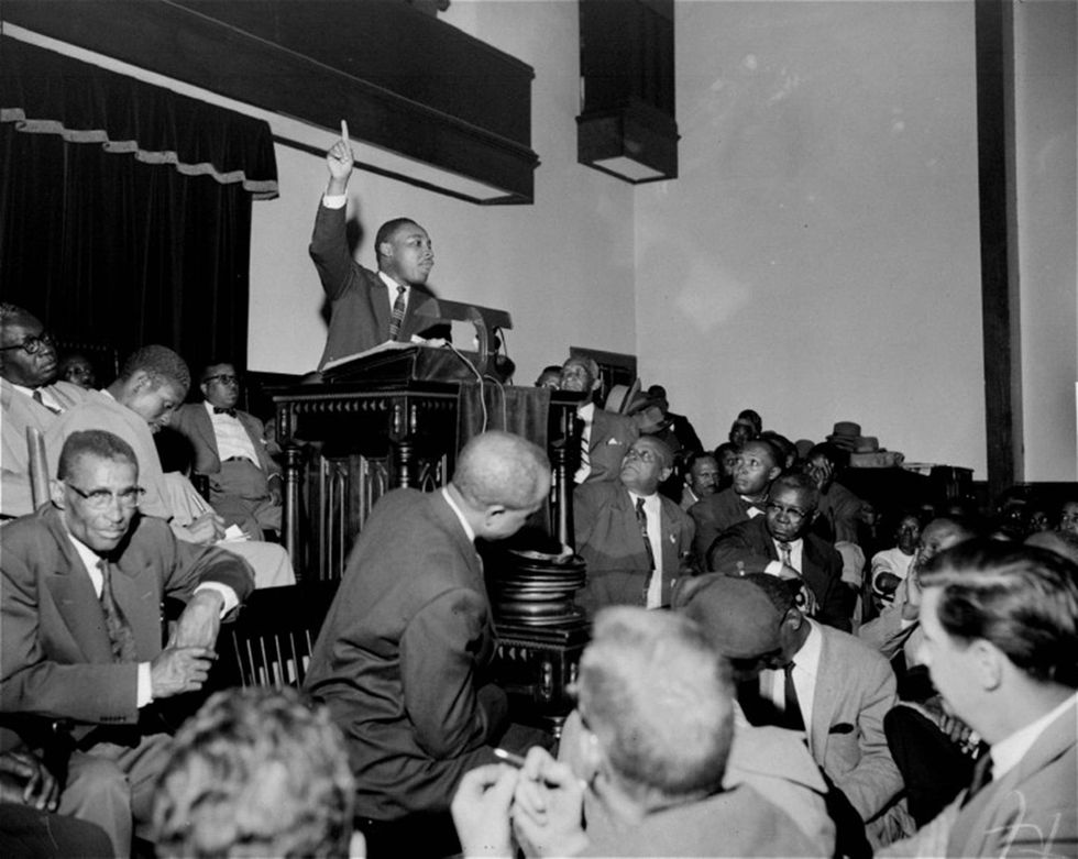 The Rev. Martin Luther King Jr. points skyward as he speaks at a mass meeting at Holt Street Baptist Church in Montgomery, Ala., during the Montgomery Bus Boycott