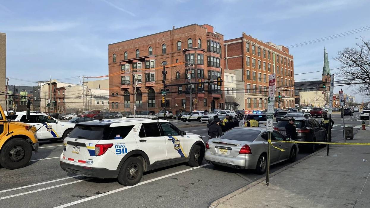 The scene on Spring Street Tuesday afternoon where, police say, people inside a pair of cars fired about a dozen shots as children were nearby with the school day ending.