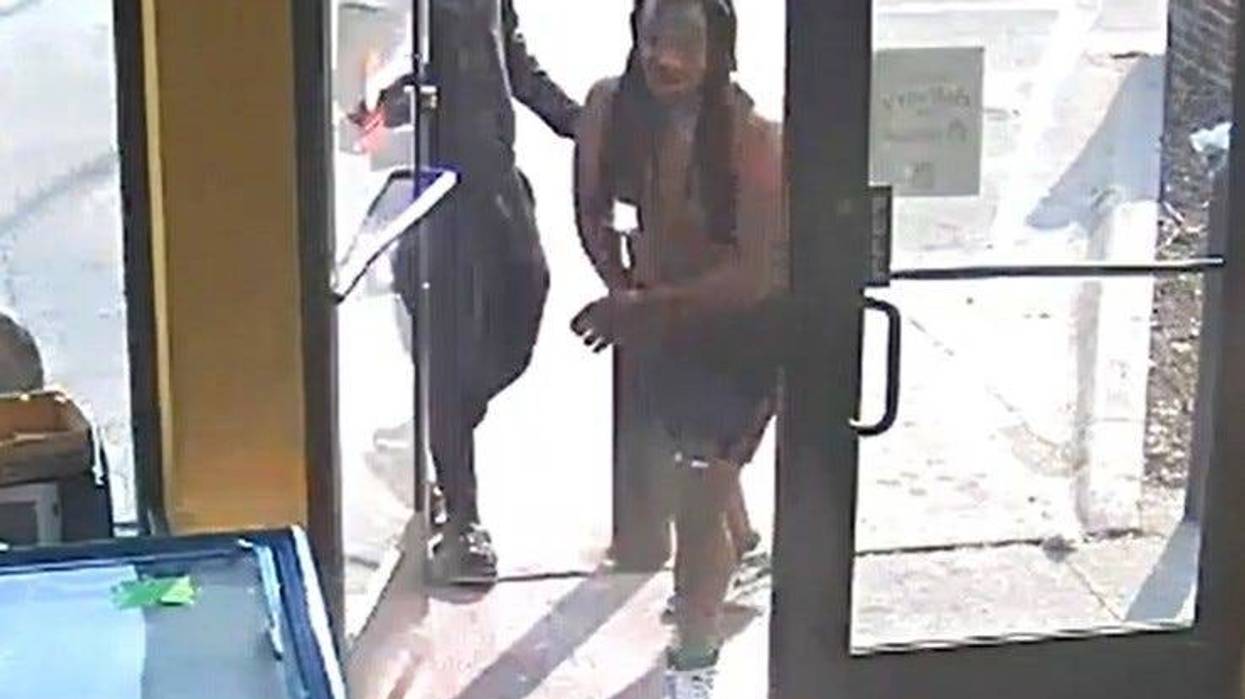 The shirtless gunman re-enters the store, before firing shots