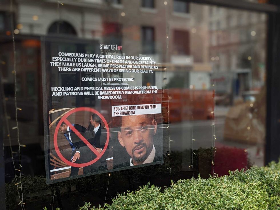 The sign includes a photo of a teary-eyed Smith accepting his best actor award shortly after the slap, along with the warning: "You: after being removed from the showroom"