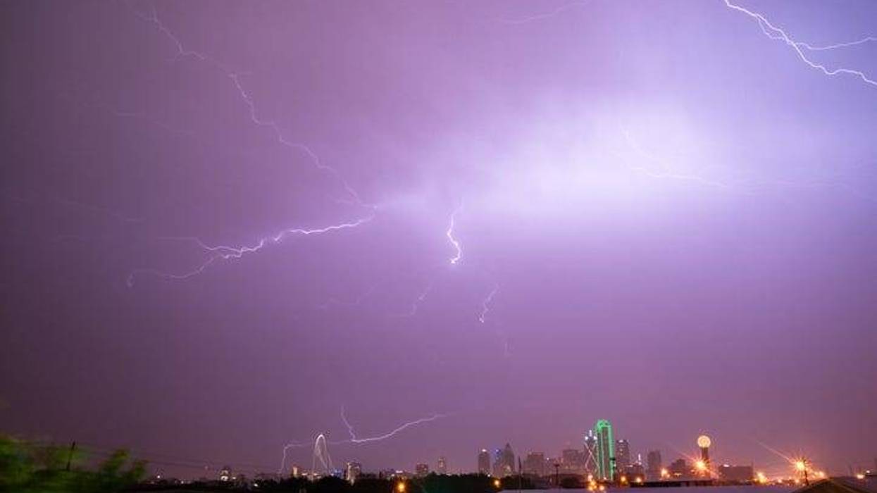 The sky is lit up purple over Dallas during a summer thunderstorm