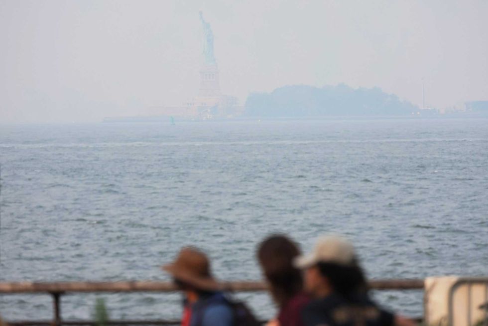The Statue of Liberty is seen amid hazy conditions due to smoke from the Canadian wildfires on June 8, 2023 in New York City