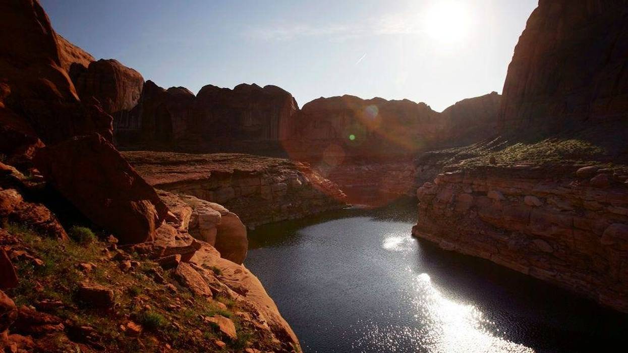 The sun rises over the low lake level, the result of a six-year drought that has dramatically dropped the level of the reservoir, in Llewellyn Gulch canyon on March 28, 2007 near Page, Arizona.