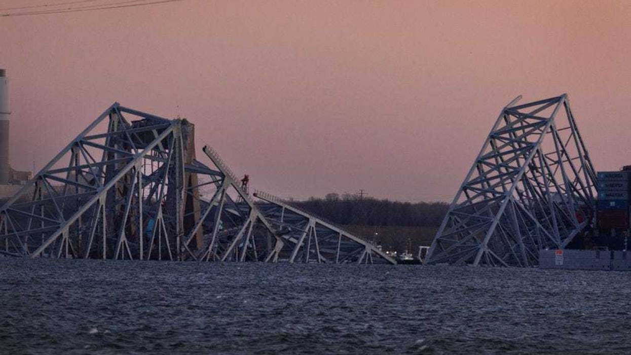 The sun sets on the collapsed Francis Scott Key Bridge on March 29, 2024 in Baltimore, Maryland. The bridge, which was used by roughly 30,000 vehicles each day, fell into the Patapsco River after being struck by the Dali, a cargo ship leaving the Port of Baltimore at around 1:30am on Tuesday morning on March 26th. The bodies of two men who were on the bridge at the time of the accident have been recovered from the water, four other are still missing and presumed dead, two others were rescued and treated for injuries shortly after the accident. The Port of Baltimore, one of the largest and busiest on the East Coast of the U.S., remains temporarily closed due to the incident. (Photo by Scott Olson/Getty Images)