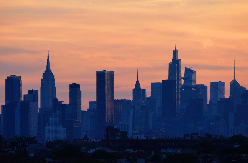 The sun sets over the New York City skyline, as seen from Arthur Ashe Stadium in Queens