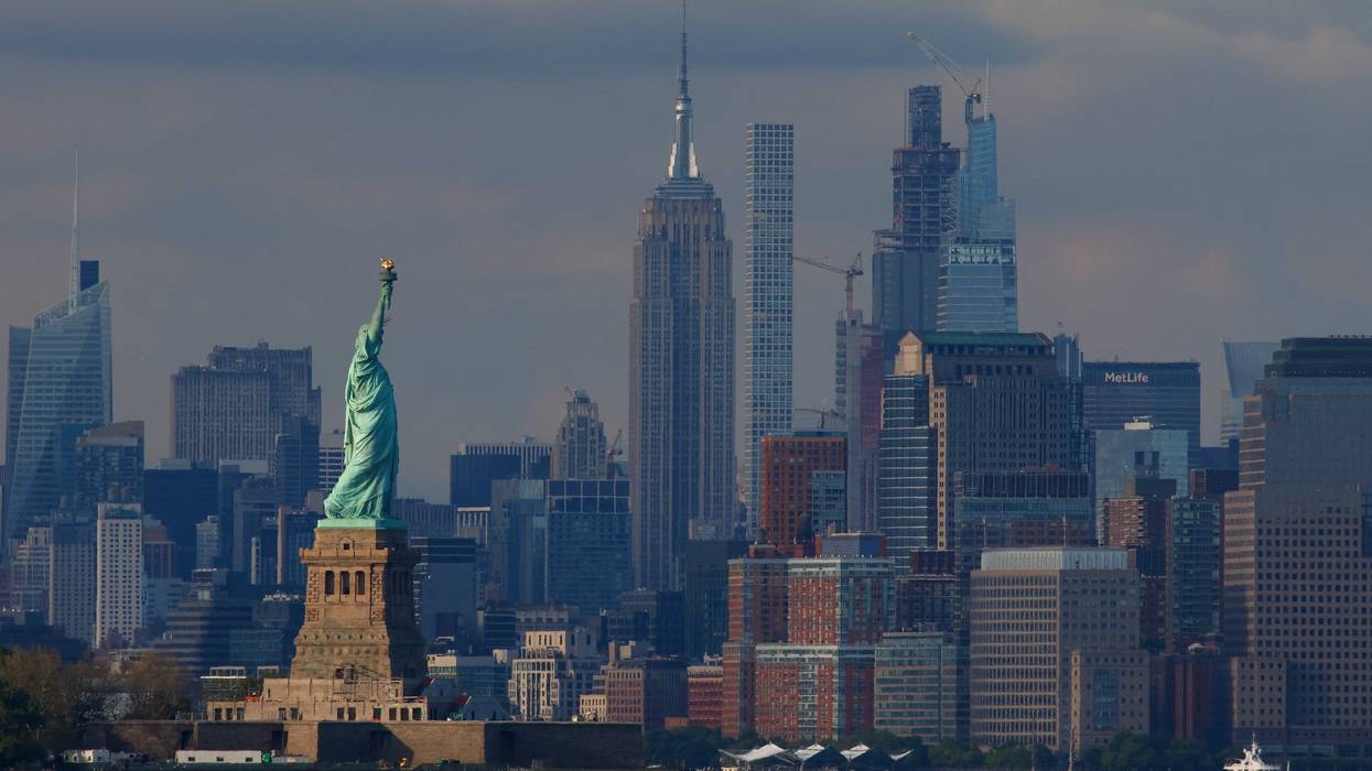 The sun sets over the Statue of Liberty and the Manhattan skyline on May 12, 2024, as seen from Bayonne, New Jersey