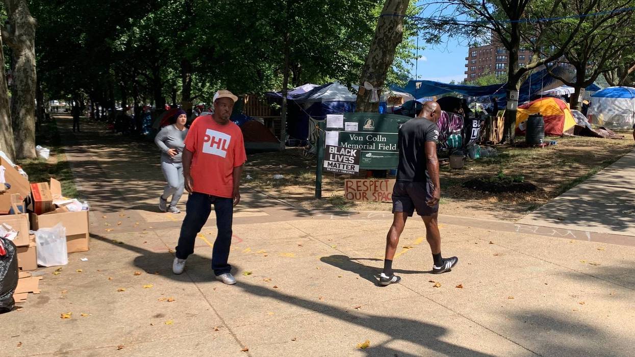 The tent encampment at Von Colln Field on the Benjamin Franklin Parkway doubles as a protest for homeless rights, but neighbors have raised concerns over sanitation.