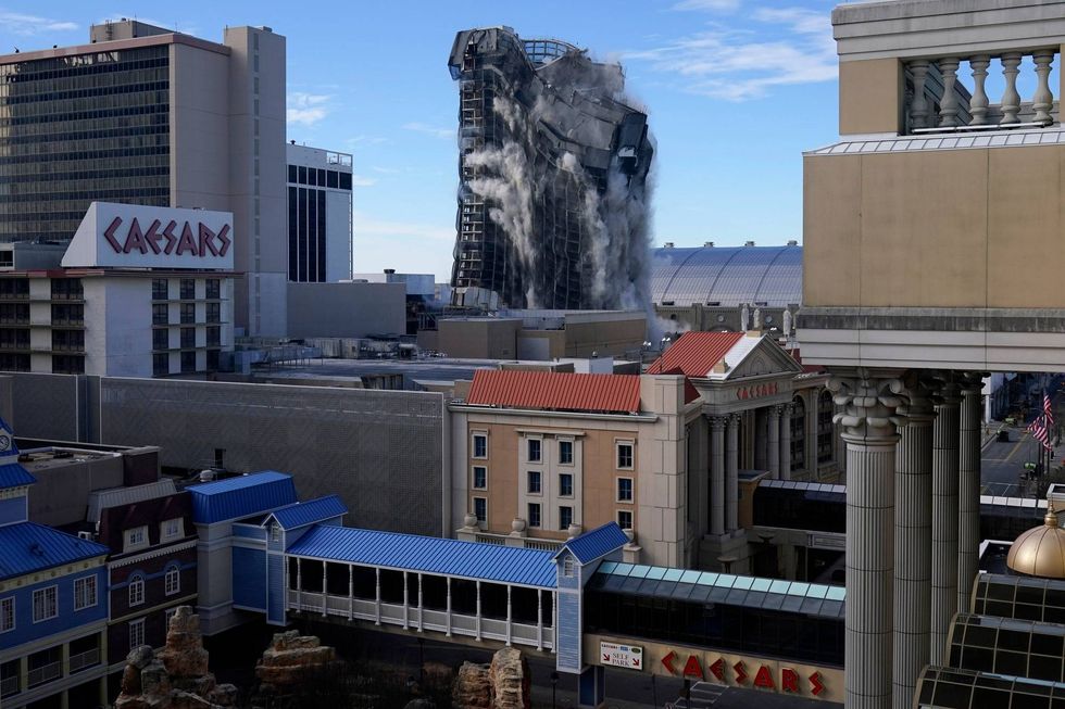 The Trump Plaza casino begins to crumble as a demolition crew detonates charges designed to knock the supports out from under it.