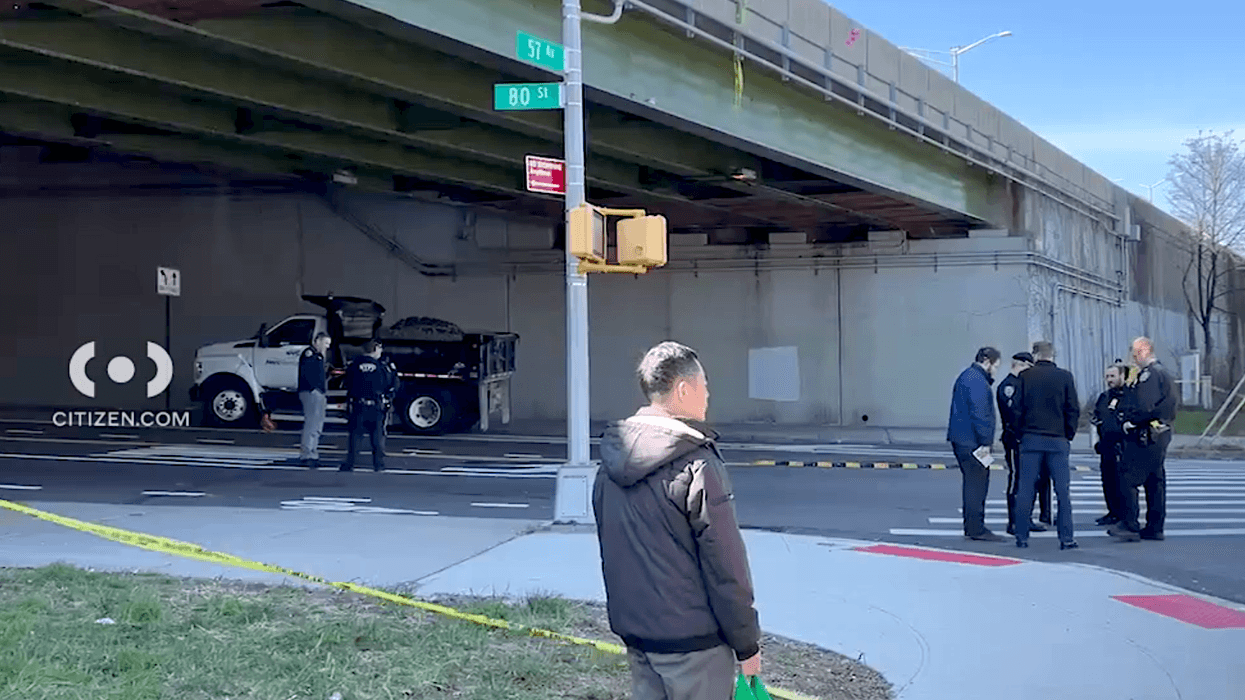 The woman was hit by a turning DEP truck in Elmhurst Tuesday morning, police said