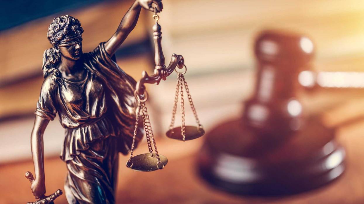 Themis statue, judge hammer and books. Courtroom