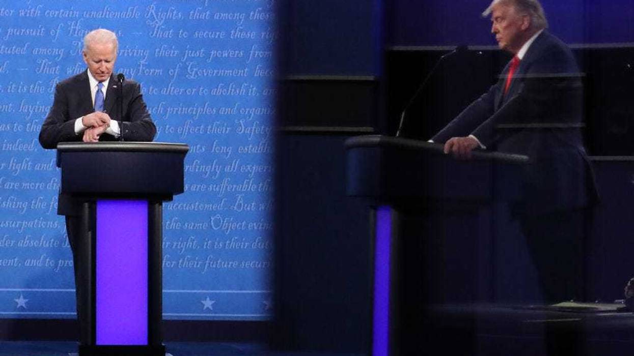 Then-Democratic presidential nominee Joe Biden checks his watch during the final presidential debate against then-U.S. President Donald Trump (shown in reflection) at Belmont University on October 22, 2020 in Nashville, Tennessee.