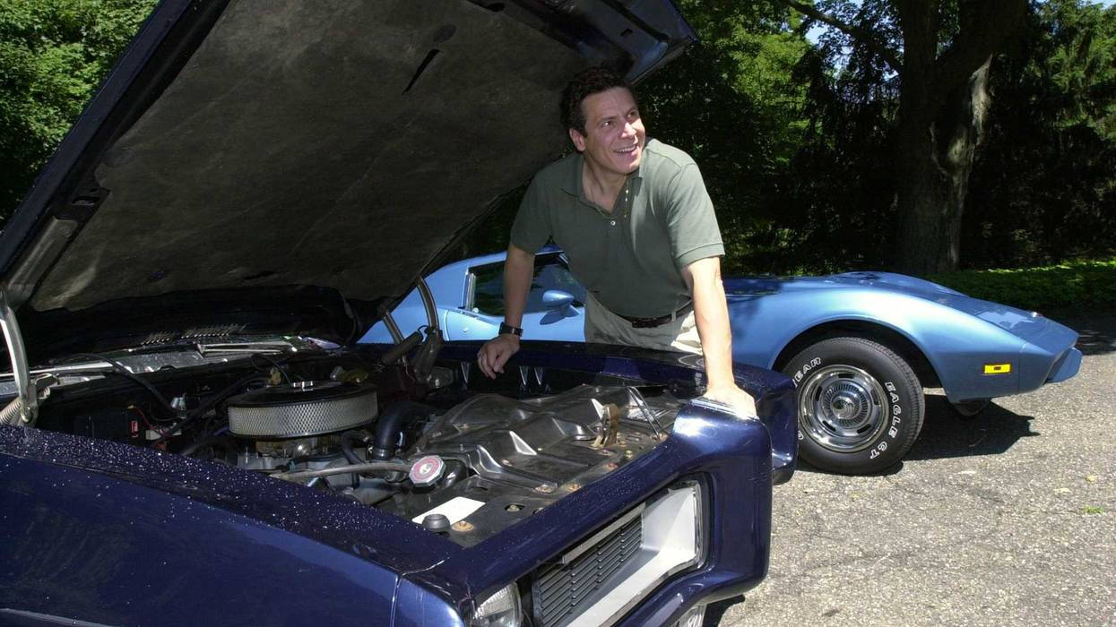 Then-gubernatorial hopeful Andrew Cuomo looks over his 1968 Pontiac GTO (front) and his 1975 Corvette at his Mount Kisco, New York, home on June 28, 2002