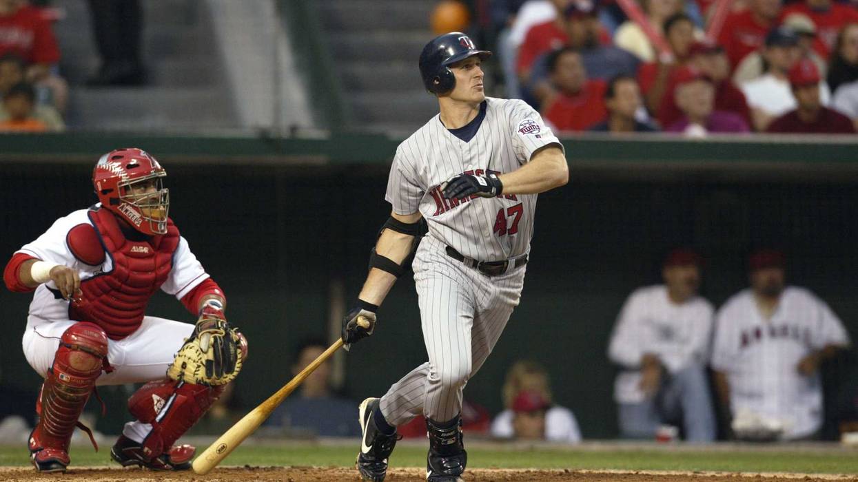 Third baseman Corey Koskie #47 of the Minnesota Twins watches the ball in flight after contact during Game four of the American League Championship Series against the Anaheim Angels at Edison International Field on October 12, 2002 in Anaheim, California.