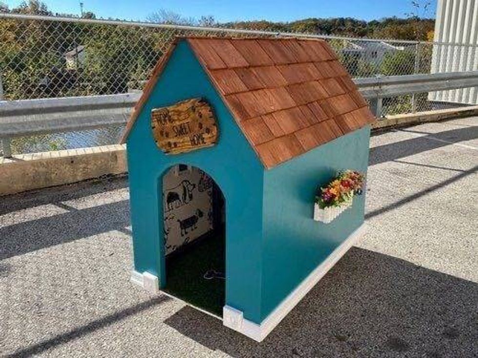 This dog house, with wooden shingles and dog wallpaper, will benefit Alex