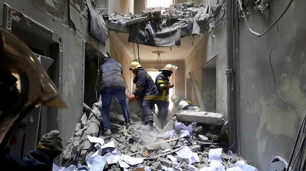 This handout photo released by Ukrainian Emergency Service shows emergency service personnel inspecting the damage inside the City Hall building in Kharkiv, Ukraine, Tuesday, March 1, 2022