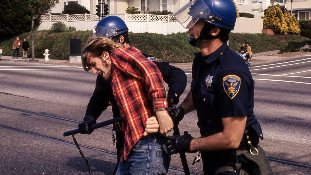 This image features two San Francisco police officers holding batons arresting a man.