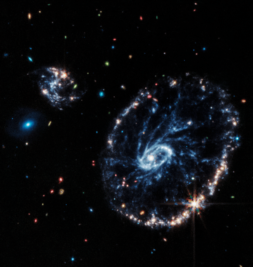 This image from Webb’s Mid-Infrared Instrument (MIRI) shows a group of galaxies, including a large distorted ring-shaped galaxy known as the Cartwheel.