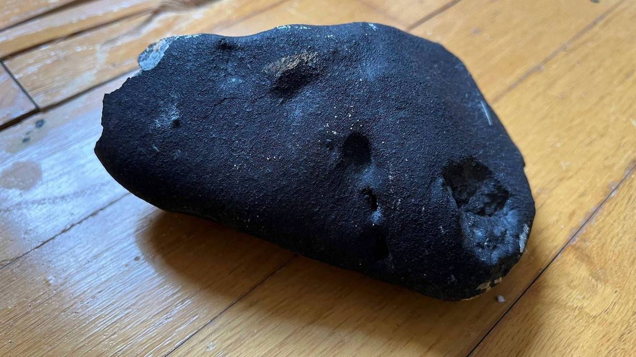 This image provided by Hopewell Township Police Department shows a metallic object believed to be a meteorite on a hardwood floor at a residence in Hopewell Township, N.J.