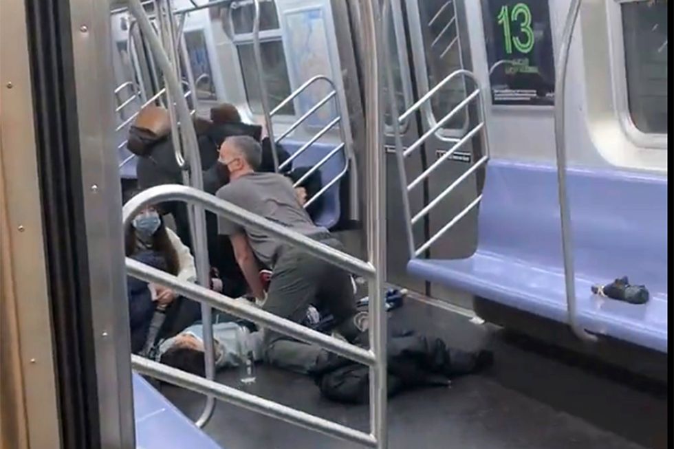 This photo provided by Will B Wylde, a person is aided in a subway car in the Brooklyn borough of New York, Tuesday, April 12, 2022. A gunman filled a rush-hour subway train with smoke and shot multiple people Tuesday, leaving wounded commuters bleeding on a Brooklyn platform as others ran screaming, authorities said. Police were still searching for the suspect.