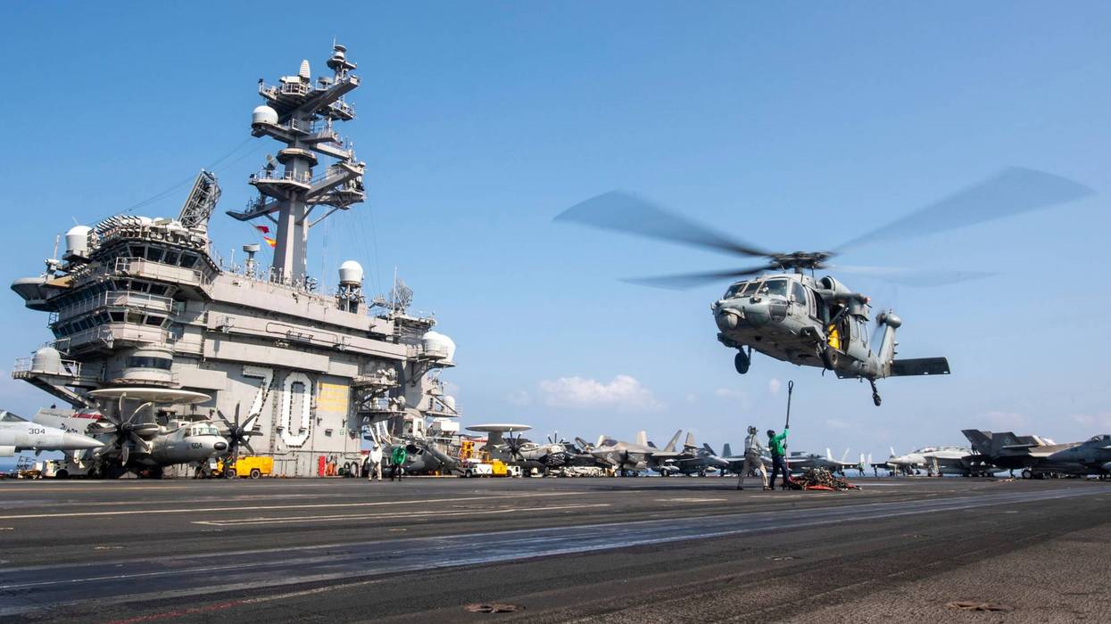 This photograph released by the U.S. Navy shows a MH-60S Sea Hawk helicopter hovering over the USS Carl Vinson aircraft carrier while operating in the Middle East on April 12, 2025.