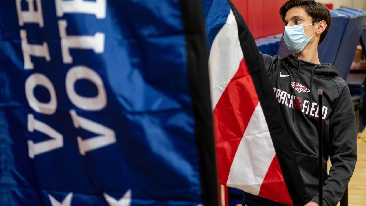 Thomas Hedrich sets up voting flags at a polling location in Gwinnett County, Ga., outside of Atlanta on Monday, Jan. 4, 2021, in advance of the Senate runoff election.