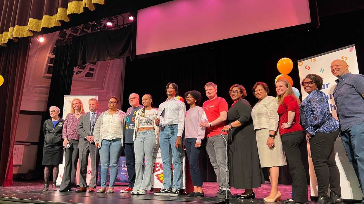 Three Chicago Public Schools seniors (center) pose for a photo after they received a surprise scholarship on Monday to help them neavigate the next step of their education.