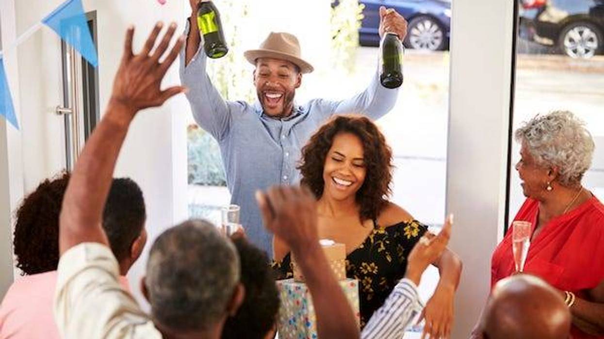 Three generation family throwing a surprise party welcoming guests at the front door