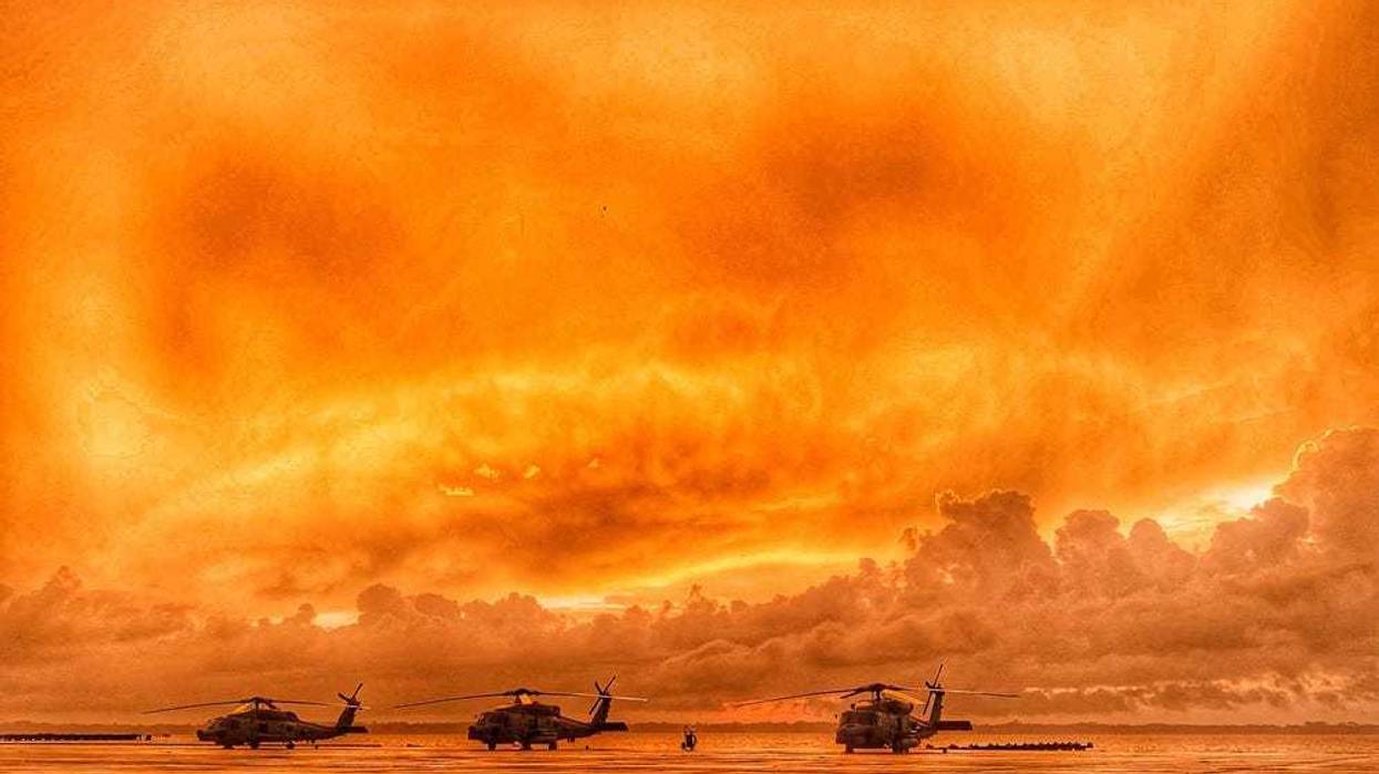 Three MH-60R Sea Hawk helicopters line the seawall as the sun rises over the St. Johns River at Naval Air Station Jacksonville, Fla.