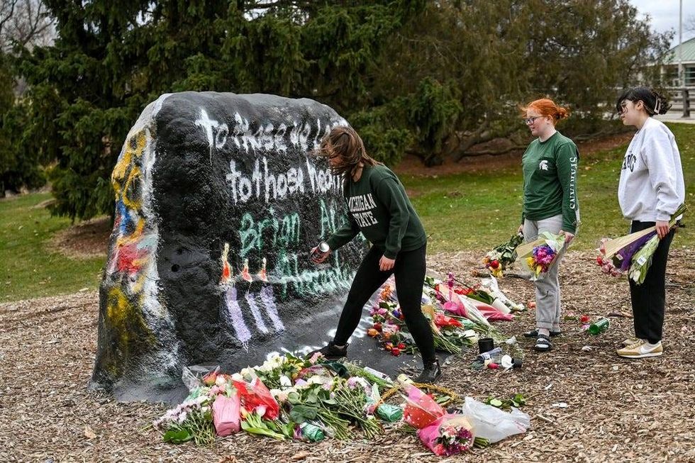 Three Michigan State student who wished to only speak to university media paints The Rock at MSU with the message, \To