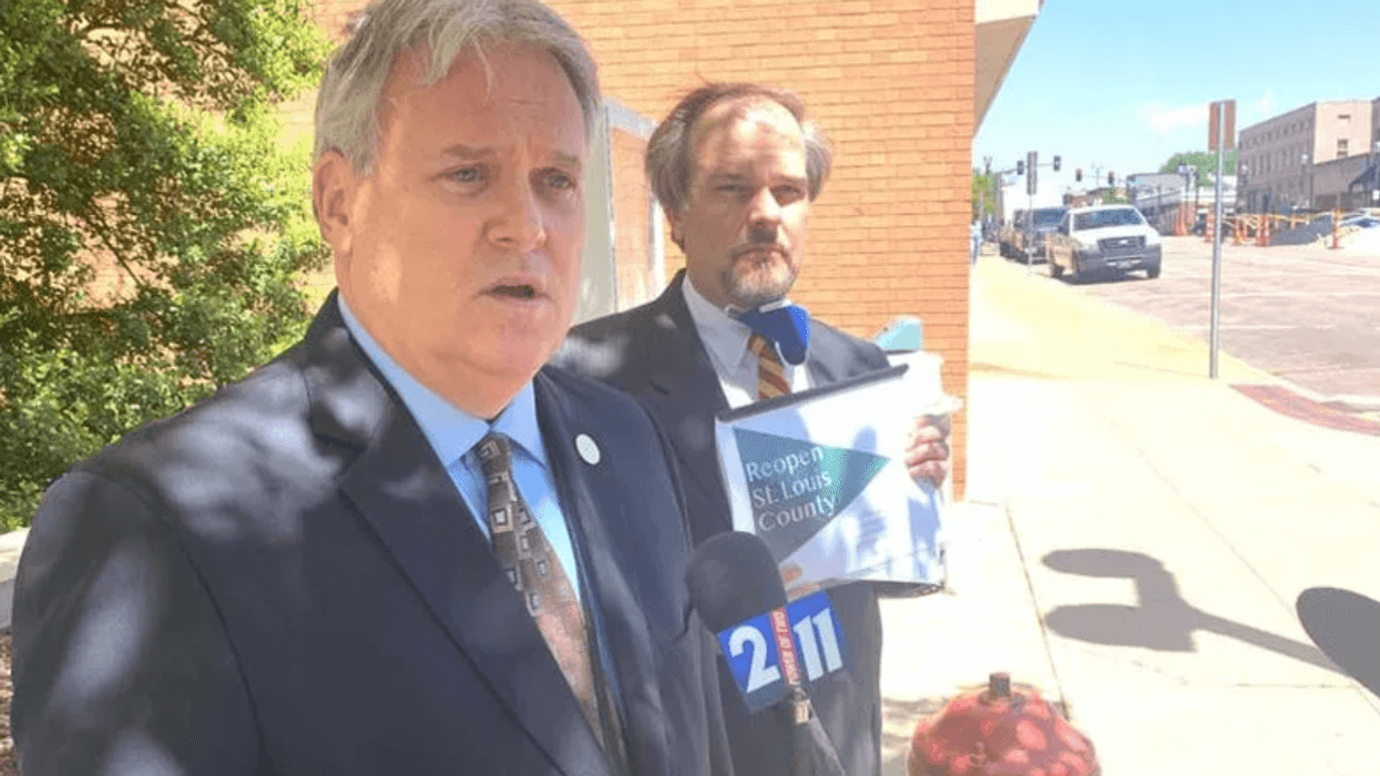 Tim fitch stands with a guy on a sidewalk