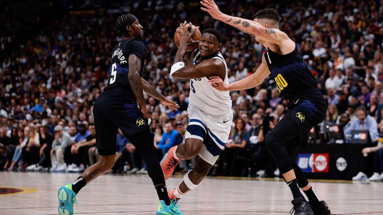 Timberwolves guard Anthony Edwards (5) drives to the basket against Denver Nuggets guard Kentavious Caldwell-Pope (5) and forward Michael Porter Jr. (1) in the first quarter during game five of the second round for the 2024 NBA playoffs at Ball Arena.