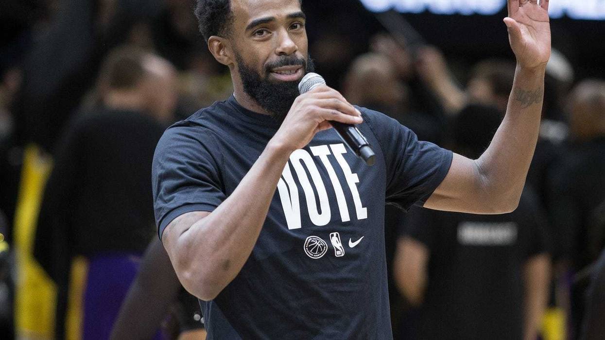 Timberwolves point guard Mike Conley encourages fans to go vote during a game in 2022.