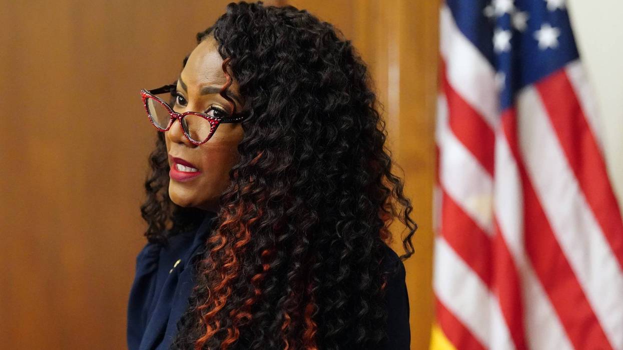 tishaura jones speaks at a podium with curly hair and sparkly red glasses very cool