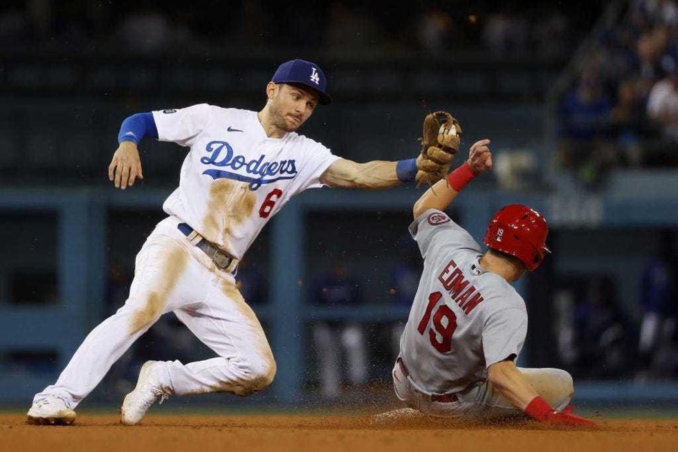 Tommy Edman #19 of the St. Louis Cardinals steals second against Trea Turner #6 of the Los Angeles Dodgers in the ninth inning.