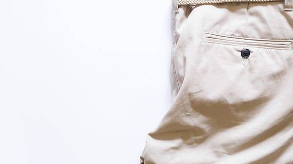 Top view of khaki shorts with braided belt on white background