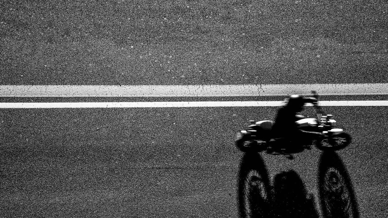 Top view of the Biker driving his motorcycle on the asphalt road